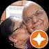 Elderly woman kissing a smiling man on the cheek in a circular profile picture.