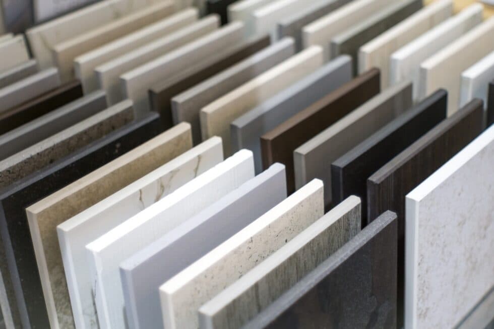 Assorted rectangular countertop and tile samples in various colors and textures arranged in neat rows.